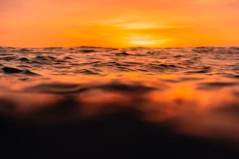 Sunset and waves in ocean. Warm water texture with bokeh Stock-Fotos