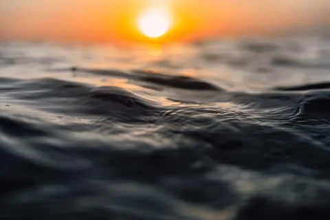 Sunset and waves in ocean. Warm water texture with bokeh 写真素材