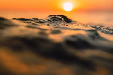 Sunset and waves in ocean. Warm water texture with bokeh 写真素材