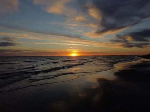 Sunset on Atlantic ocean Argentine coasts, brown sand and waves. Monte Hermoso Stock Photos