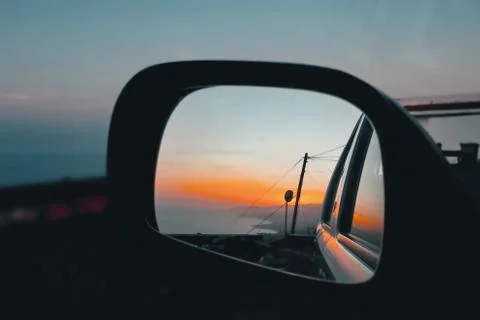 Sunset at the Atlantic through the left side mirror evening sky Stock Photos