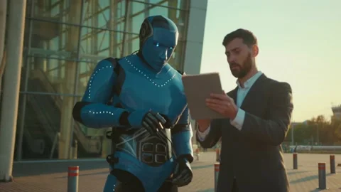At sunset attractive man use tablet computer talking with humanoid robot shake Stock Footage 133298750