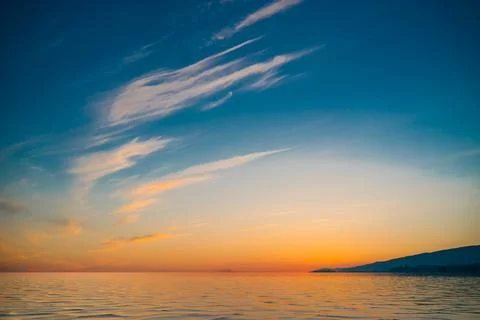 Sunset on the background of bright blue sky with white Cirrus clouds on a b.. Stock Photos