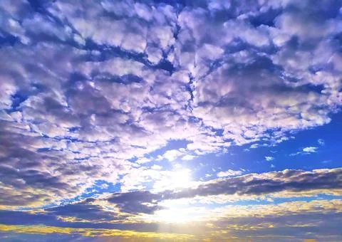 Sunset on the background of clouds and blue sky Stock Photos