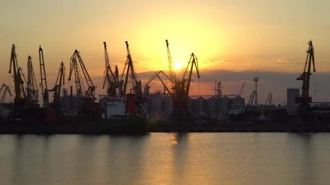 Sunset on a background of cranes at the port Stock Photos