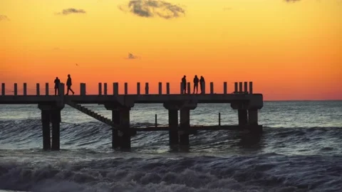 Sunset on the background of the pier where silhouettes of people walk. Stock Footage 167024725