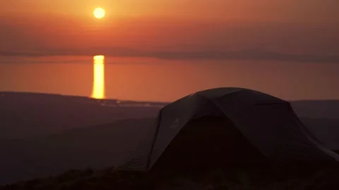 Sunset background with a tent high in the mountains Vídeo Stock 220293044