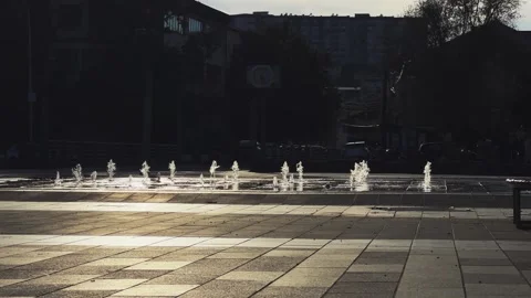 Sunset backlit fountains create a mesmerizing effect in an urban square at tw Video stock 297438959