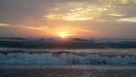 Sunset in bali the waves are breaking on the beach the sky is very beautiful 库存影片 126970291