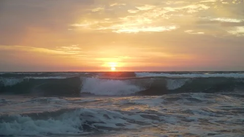 Sunset in bali the waves are breaking on the beach the sky is very beautiful 库存影片 126971565