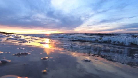 Sunset on the Baltic Sea shore with wave splashes in the camera at ground level Stock Footage 151003556