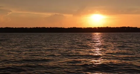 Sunset on the banks of the river, the sun sets in small thunderclouds. Warm summ Video stock 168182705
