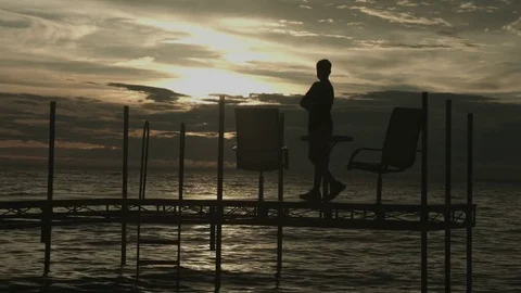 Sunset on Bay with Pier &amp; Boy Stock Footage 82976013