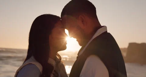 Sunset, beach and couple with face together by ocean for commitment, bonding and Stockbeeldmateriaal 250384205