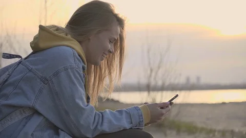 Sunset beach and girl using smartphone for chatting Video stock 91055486