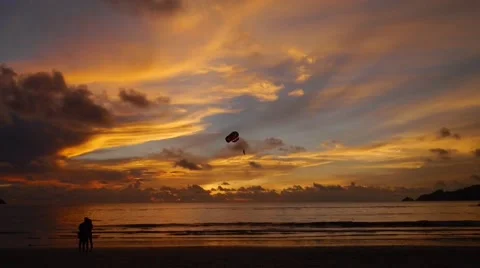 Sunset on the beach and people taking a parachute in the sky Stock Footage 43211668