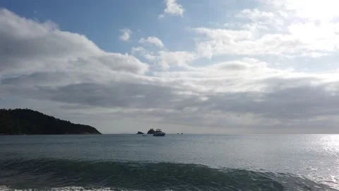 Sunset on a beach in Brazil with a few clouds and a yacht in the sea Video stock 167484610