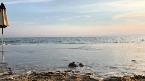 Sunset Beach with Closed Umbrella and Gentle Sea Waves Stock Footage 341380710