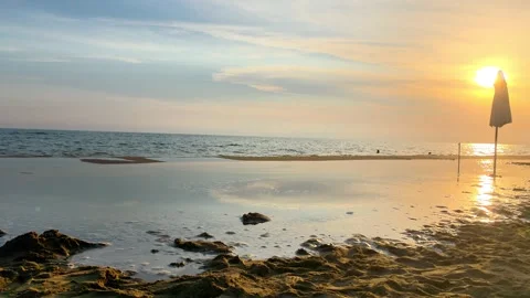 Sunset Beach with Closed Umbrella by Calm Sea Horizon Stock Footage 341380640