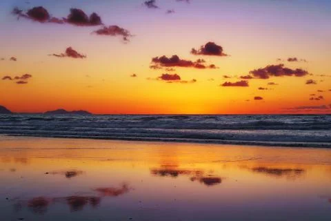 Sunset on beach with cloud reflections Stock Photos