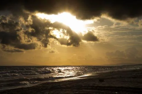 Sunset on the beach with cloudy sky Stock Photos