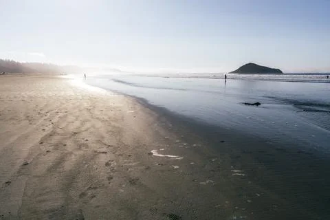 Sunset beach with distant figures Stock Photos