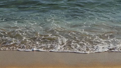 Sunset on a beach. Foamy waves rolling towards white sand beach under the sun Stock Footage 303896458