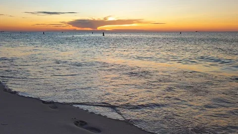 Sunset on the beach with footprints in the sand Stock Footage 130078503