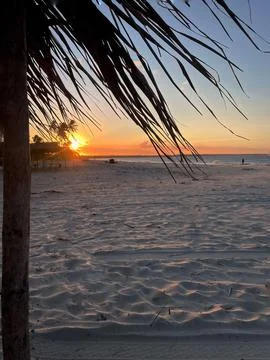 Sunset on the beach framed by a hut Stock Photos