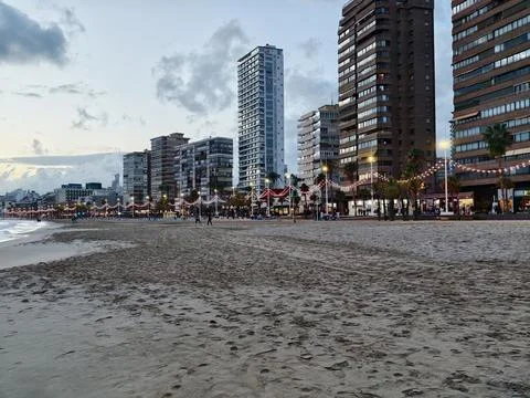 Sunset beach with lights, Serene night at coastal boardwalk with illuminate.. Stock Photos