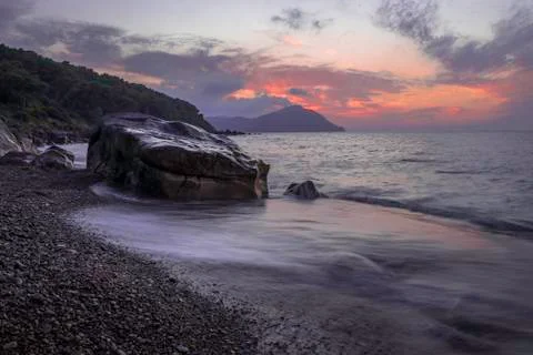 Sunset at beach in long exposure waves of ocean . Algeria Stock Photos
