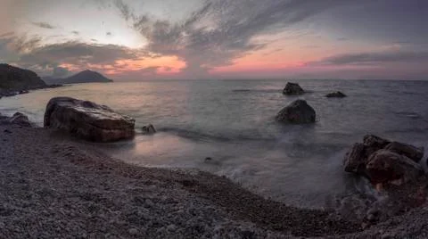 Sunset at beach long exposure with waves and clouds Stock Photos