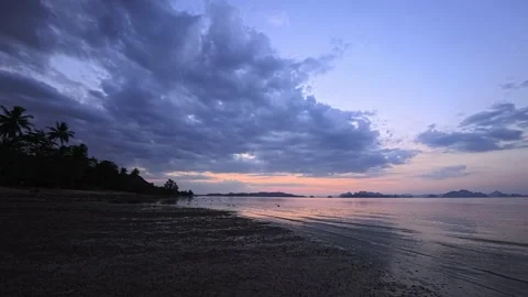 Sunset on a beach at low tide on a tropical paradise island with palm trees  Vídeo Stock 331868096