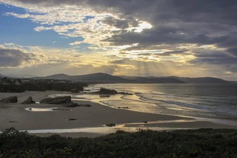 Sunset in a beach with many rocks Stock Photos