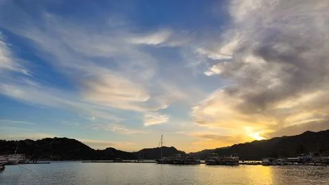 Sunset by the beach with mountain and clouds Stock Photos