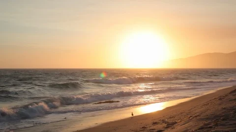 Sunset. On beach ocean water. slowmo pan Stock Footage 102403978