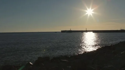 Sunset on the beach with pier on the background. Video stock 76849404