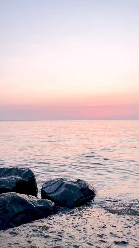 Sunset on the beach in pink shades. Small waves softly lapping against the .. Stock Footage 314219186