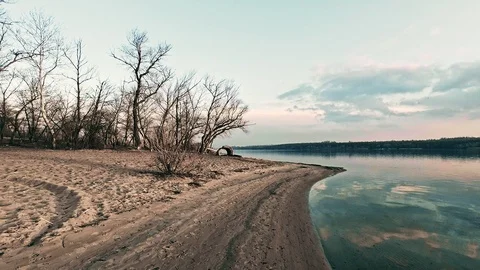 Sunset on the beach of the river with devias on the shore and clouds Stock Footage 125103523