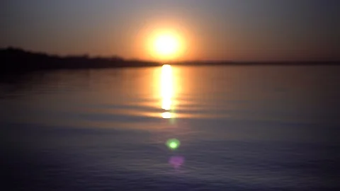 Sunset on beach of the river or lake, waves water close up Stock Footage 130071228