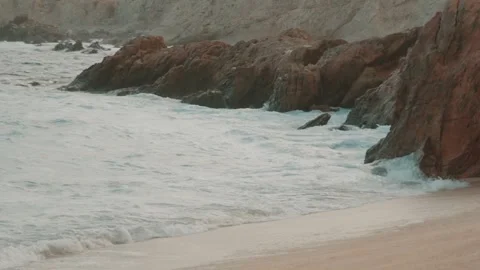 Sunset on the beach with rocks in the background and some palm trees. Stock Footage 280446779