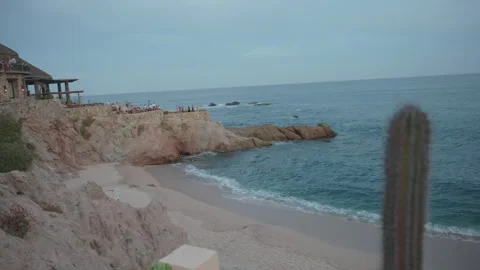 Sunset on the beach with rocks in the background and some cacti, golden hour Stock Footage 280446970