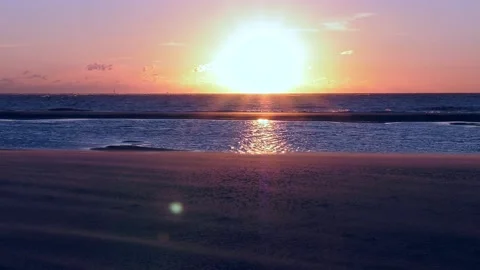 A sunset on the beach by the sea with small waves 動画素材 234993636