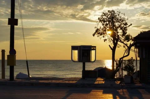 Sunset at the beach with shadows on the road. Stock Photos