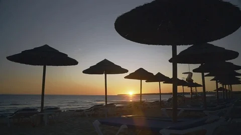 Sunset on the beach with silhouettes of the straw umbrellas against the sky. Stock Footage 83322959