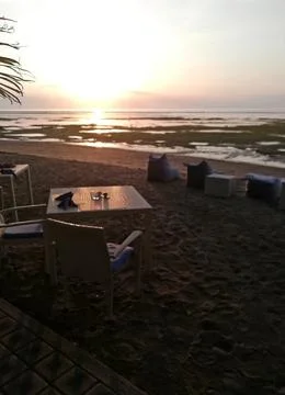 Sunset on the beach , with some empty restaurant table Stock Photos