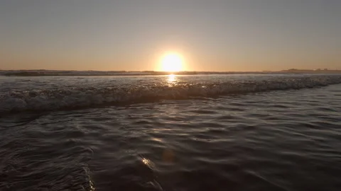 Sunset on beach in summer, waves rush towards camera and splash Stock Footage 135418999