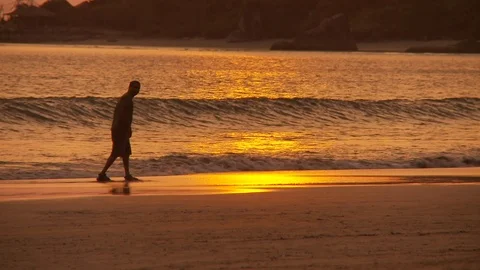 Sunset beach, sun relfection on wet sand, kid playing football, Mid shot Stock Footage 125747132