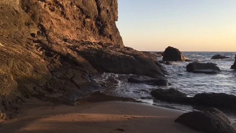 Sunset on the beach, sunbeam on a volcanic rock Stock Footage 121145104