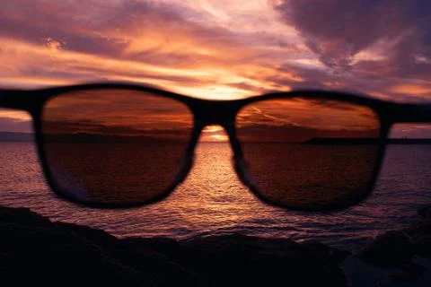 Sunset on the beach with sunglasses Stock Photos